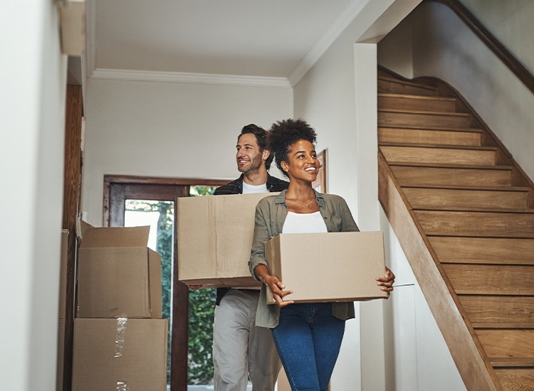 Couple entrant dans leur nouvelle maison avec des boîtes